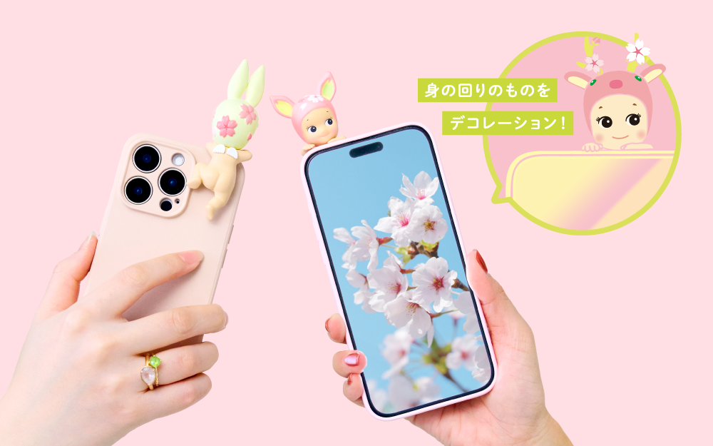 Cherry Blossom HIPPERS product image set on a soft pink background show two cell phones featuring the front and back of two Cherry Blossom HIPPERS. Left: a pink phone shows the back of the Rabbit HIPPER variant. Right: front facing cell phone shows an image of cherry blossoms, with the Fawn Cherry Blossom HIPPER looking out over the image.